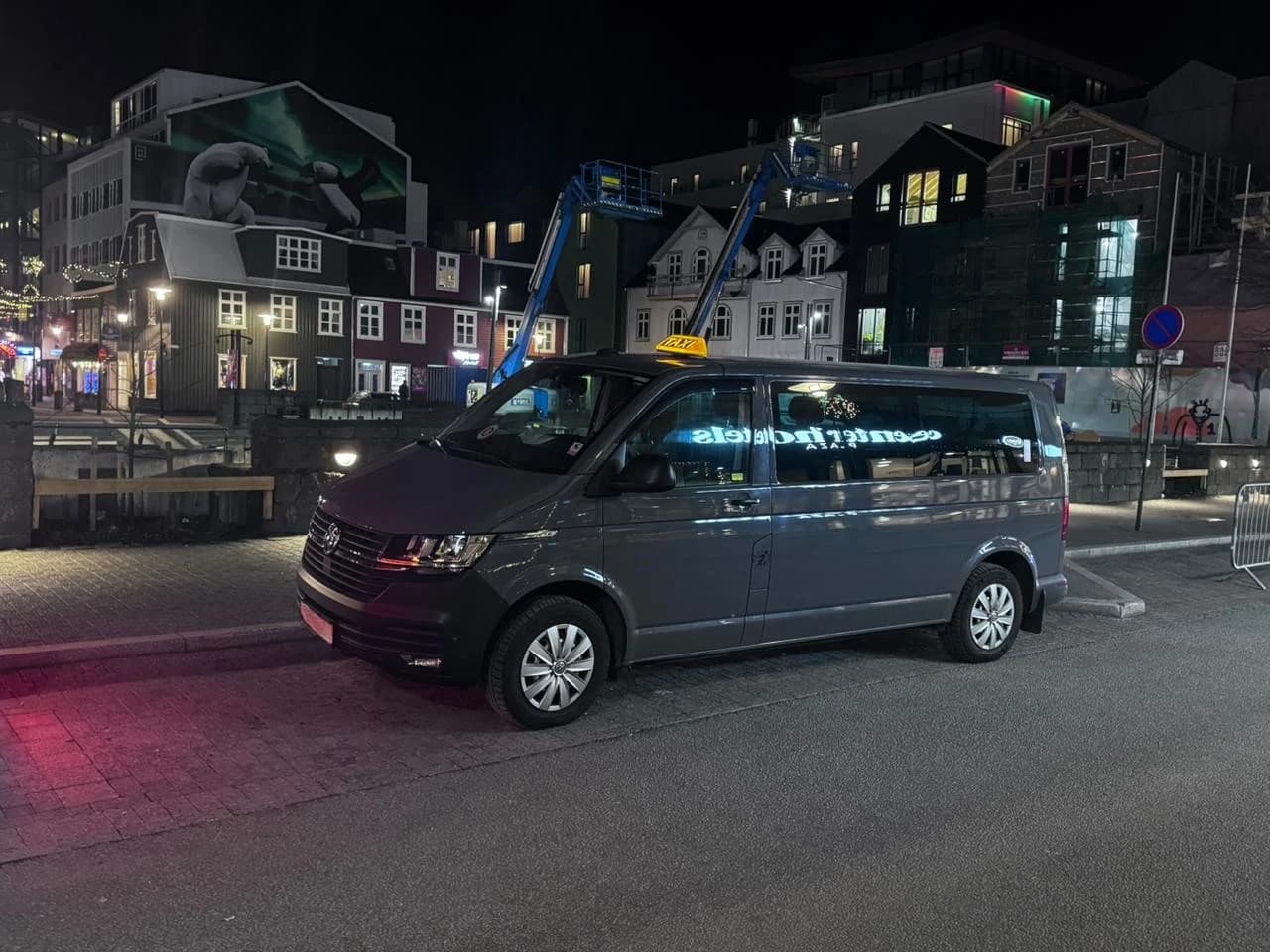 The Iceland Shuttles Volkswagen Caravelle, a licensed taxi, at night in downtown Reykjavík